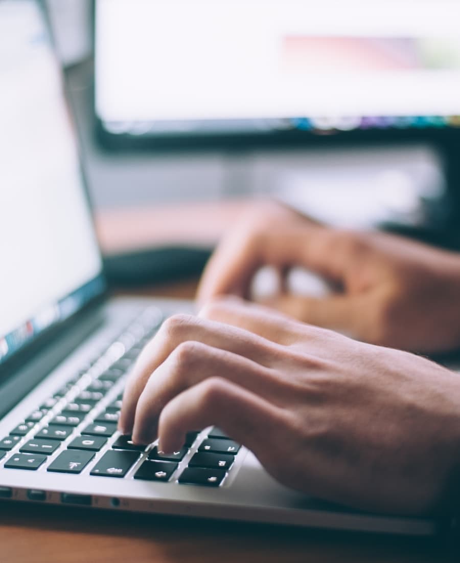Hands typing a blog post on a laptop